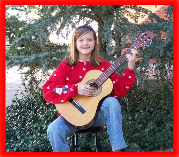 Young girl enjoying a classical guitar lesson